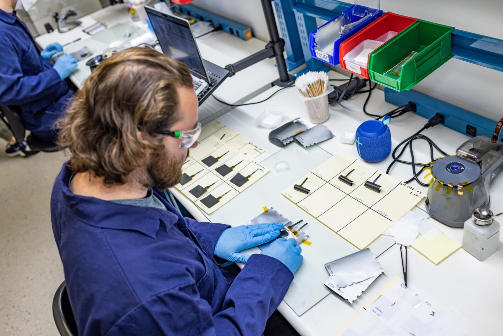 Alsym Battery Lab with technicians working on battery testing and research equipment.